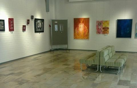 Pääkirjaston näyttelytila, marmorilattia, tauluja seinillä, sohvaryhmä