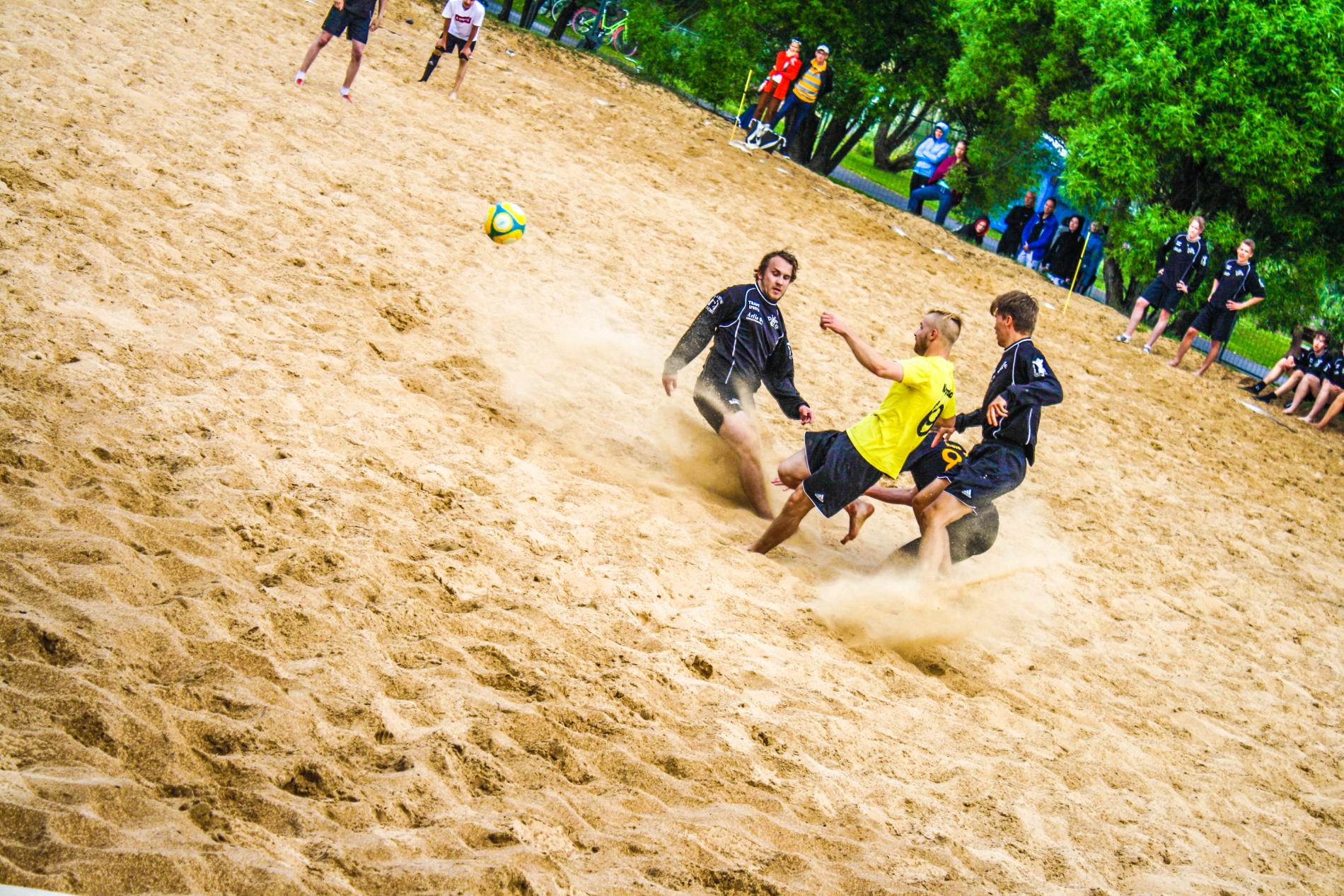Игра в пляжный футбол на песчаном пляже.